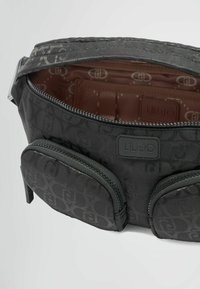 Borsa in tessuto nero con chiusura a zip, dotata di due tasche esterne e una fodera interna liscia con motivo a logo. Contrassegnata con l'etichetta "LIU-JO".
