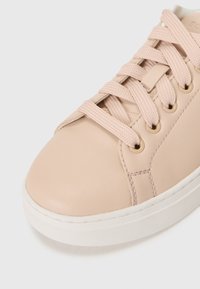 Sneaker in pelle rosa chiaro con superficie testurizzata, punta rotonda e suola piatta in gomma bianca. Presenta lacci piatti e occhielli in metallo.