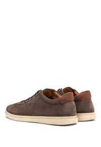 Zapatillas de ante marrón con un acento en el talón de cuero color beige, suelas de goma beige y un diseño minimalista; cuenta con cordones y detalles perforados.