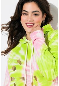 Sudadera con capucha en patrones tie-dye de rosa y verde neón, con detalles dorados y cordones blancos. Tejido suave con un ajuste relajado.