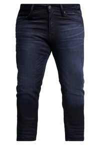 Dark blue denim jeans with a slim fit, featuring a classic five-pocket design and a button fly, exhibiting a smooth texture.