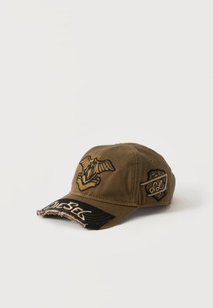 Casquette de baseball marron avec visière noire usée, emblème d'oiseau sur le devant et logo en forme de bouclier sur le côté, affichée sur fond blanc.