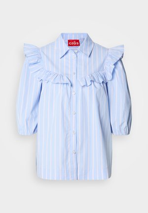 Ljust blå randig skjorta med volangdetaljer på axlarna och fram, med en spetsig krage och knäppning framtill.