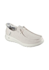 Zapatos slip-on de color gris claro con tejido texturizado, suela blanca y plantilla con un patrón floral. Presentan un minimalismo en el cordón para un ajuste relajado.