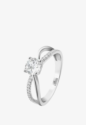 Bague en argent avec un diamant rond central, dotée d'un anneau lisse et de petites pierres d'accent le long d'un côté, mettant en valeur un design épuré.