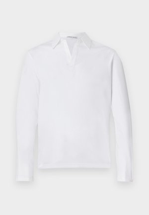 Biała długi rękaw polo wykonana z bawełny z ostro zakończonym kołnierzykiem i częściowym zapięciem. Miękka bawełniana tkanina o gładkiej fakturze. Brak widocznych akcentów.