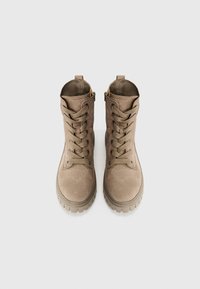 Bottines en suede marron avec des bouts ronds, semelles en caoutchouc et œillets métalliques ; présentent un design de laçage robuste et une languette à l'arrière.