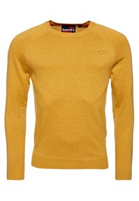 Maglione giallo in maglia realizzato in tessuto morbido, con scollo a girocollo e maniche lunghe. Patch con logo sul lato sinistro del petto, polsini e orlo a coste.