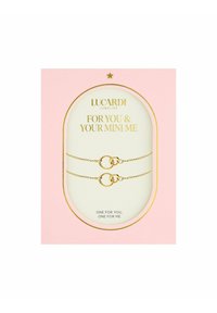 Gouden armbanden met vergrendelbare ringen, weergegeven op een roze kaart met gouden letters die leest: "Voor Jou & Je Mini Me."
