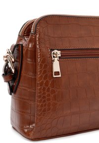 Borsa in pelle marrone con texture a coccodrillo, dotata di una cerniera e dettagli dorati, con una tasca frontale con zip e una tracolla removibile per una maggiore versatilità.