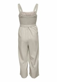 Combinaison beige clair avec un corsage smocké, bretelles réglables et pantalon à jambes larges avec taille élastiquée et détail ceinture.