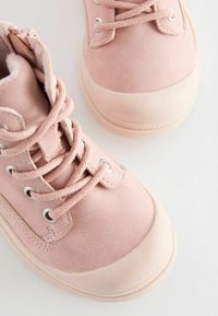 Rosa suede ankelstøvler med rund tå, snørresystem, sølvøjer og en kontrasterende gummisål. Tekstureret overflade på toppen.