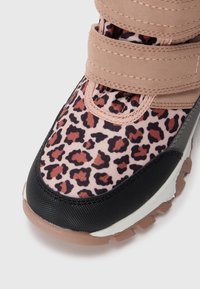 Sneaker mit Leopardenmuster, bestehend aus einer Mischung aus pinkem Stoff, schwarzer Gummisohle und Klettverschlüssen mit einem strukturierten synthetischen Oberschuh.