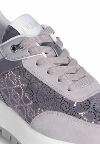 Sneaker con una combinazione di morbido suede viola e dettagli in paillettes luccicanti. Accenti grigi, lacci bianchi e una suola bianca robusta completano il design.