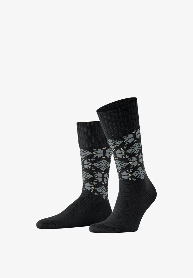 Zwarte sokken met een geribbelde bovenkant en een patroon van grijze en lichtgouden geometrische vormen. Zachte textuur; lengte tot halverwege de kuit.