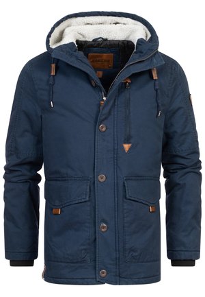 Veste bleu marine avec capuche bordée de fourrure, fermeture éclair et boutons, deux poches avant et accents en cuir sur la fermeture éclair et les bords des poches.