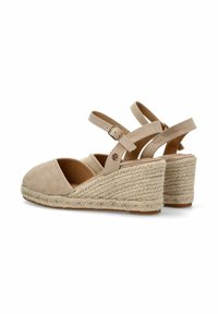 Sandalias de cuña de ante beige con una plataforma trenzada de yute, dos correas ajustables en el tobillo y un diseño de punta cerrada.