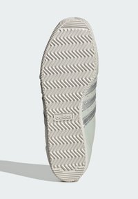 Adidas sporta apavu zole gaiši pelēkā krāsā ar zigszagveida protektora rakstu, ar trim sudraba svītrām sānos un teksturētu gumijas apdari.