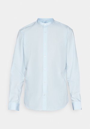 Chemise longue à manches longues de couleur bleu clair, en coton, avec un col bandé et une fermeture à boutons à l'avant. Texture lisse avec des poignets standards.