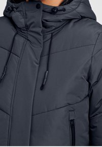 Tmavě šedá péřová bunda s vysok�ým límcem, nastavitelnou kapucí se stahovacími šňůrkami, diagonálním prošíváním a boční kapsou na zip.