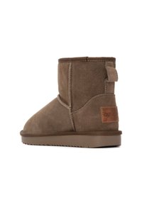 Botín de ante marrón hasta el tobillo con punta redondeada, superficie texturizada, costuras beige y una lengüeta en el talón. Presenta un parche de cuero color canela en la parte trasera.