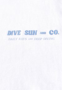 Bílá látka s modrým textem: "DIVE SUN and CO." s "DAILY RAYS and DEEP DIVING" pod ním. Text je mírně vyvýšený a texturovaný.