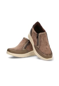 Mocasines de ante marrón sin cordones con cremalleras laterales, pequeños tachuelas metálicos y suelas de goma beige, dispuestos con un zapato apoyado sobre el otro.