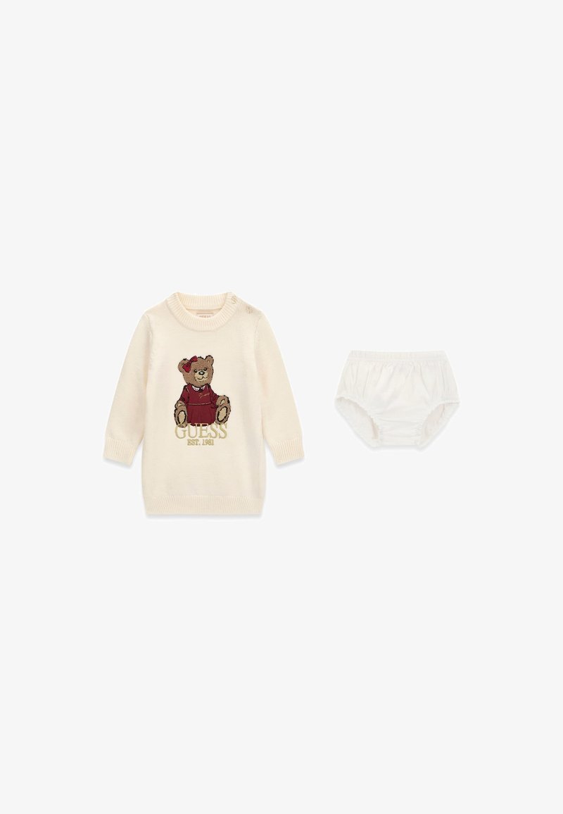 Robe-pull bébé couleur crème avec un ours en peluche portant une tenue rouge et un short de protection pour couche de couleur crème assorti.