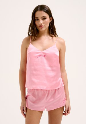 Ensemble de nuit en satin rose comprenant un top cami à bretelles spaghetti et un short, tous deux ornés d'une broderie de marque et d'une texture lisse et brillante.
