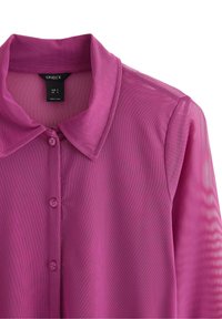 Gennemsigtig lyserød bluse med krave, knaplukning foran og korte ærmer. Fremstillet af letvægtsstof med en glat tekstur og subtilt stribet mønster.