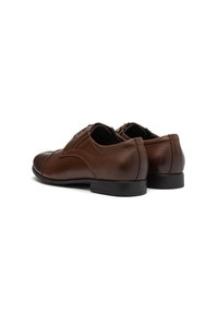 Pantofi de dress din piele maro cu o finisare netedă, având toc mic, vârf rotund și accente de cusătură subtile.