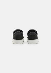 Mustad musta värvi kangast sneakers valge kummitaldaga, millel on stiilne disain ja pehmendatud pits.