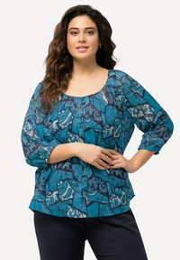 Leichte, türkise Bluse mit floralem und geometrischem Muster, Rundhalsausschnitt und 3/4-Ärmeln. Sie hat eine lockere Passform und geraffte Details.