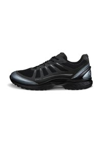 Chaussure de sport noire avec tige en mesh, accents synthétiques, détails réfléchissants, semelle rembourrée et semelle extérieure en caoutchouc texturé pour une meilleure traction.
