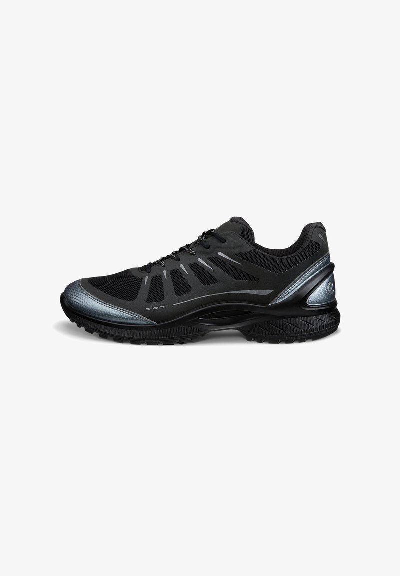 Chaussure de sport noire avec tige en mesh, accents synthétiques, détails réfléchissants, semelle rembourrée et semelle extérieure en caoutchouc texturé pour une meilleure traction.
