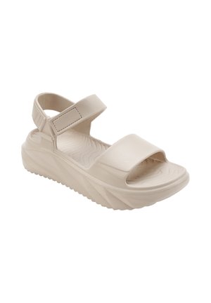 Beige platform sandaal met een gestructureerde zool, brede voorkant band en verstelbare klittenband enkelband voor een veilige pasvorm.