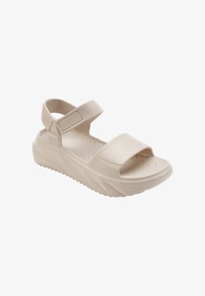 Beige platform sandaal met een gestructureerde zool, brede voorkant band en verstelbare klittenband enkelband voor een veilige pasvorm.