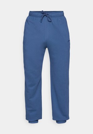 Kék bolyhos melegítőnadrág, elasztikus derékkal és húzózsinórral, elasztikus mandzsettákkal és kis logóval a comb felső részén.