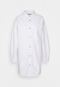 Vestido de camisa branco em algodão com fecho de botões à frente, colarinho, mangas longas e um bolso no lado esquerdo do peito. Textura suave e corte descontraído.