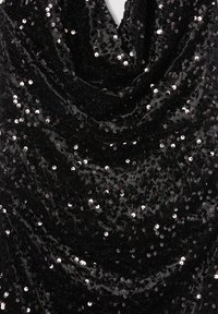 Czarna aksamitna tkanina z gęsto rozmieszczonymi małymi, odbijającymi światło srebrnymi cekinami, tworzącymi teksturowaną, błyszczącą powierzchnię.