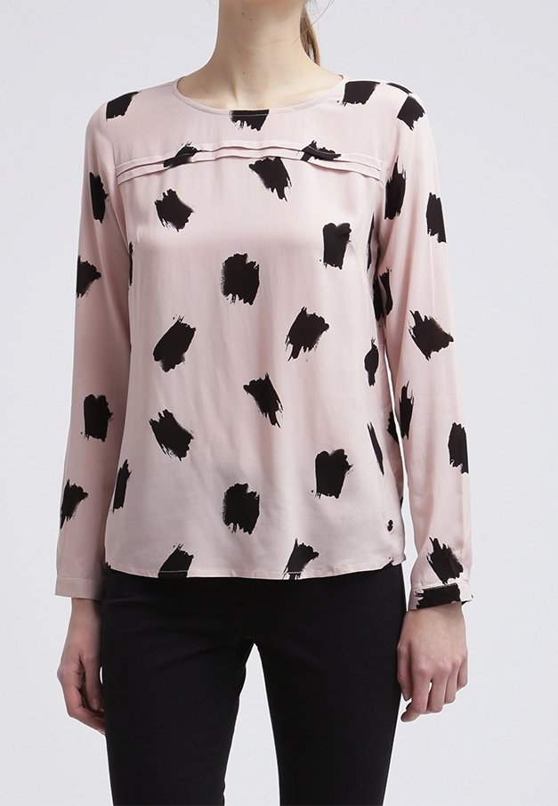 Blusa a maniche lunghe rosa chiaro con audaci motivi a pennellate nere, scollatura rotonda e dettagli a pieghe sul petto. Tessuto morbido.