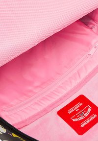 Interno di una borsa nera con rivestimento rosa texturizzato, dotato di una tasca con zip e un'etichetta rossa che indica "Edizione Limitata".