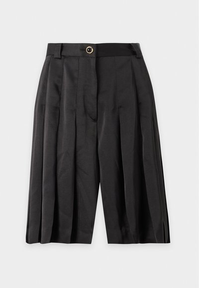Short noir plissé taille haute avec passants de ceinture et fermeture à un bouton à l'avant sur un fond uni.