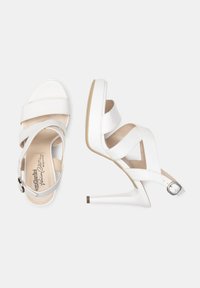 Sandales à talons hauts blanches en cuir lisse avec un design de brides croisées, boucle de cheville ajustable et un élégant bout pointu.