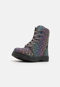 Botas de tobillo grises con patrones de corazones multicolores, superficie texturizada y cordones grises. Presentan una suela resistente de goma negra.
