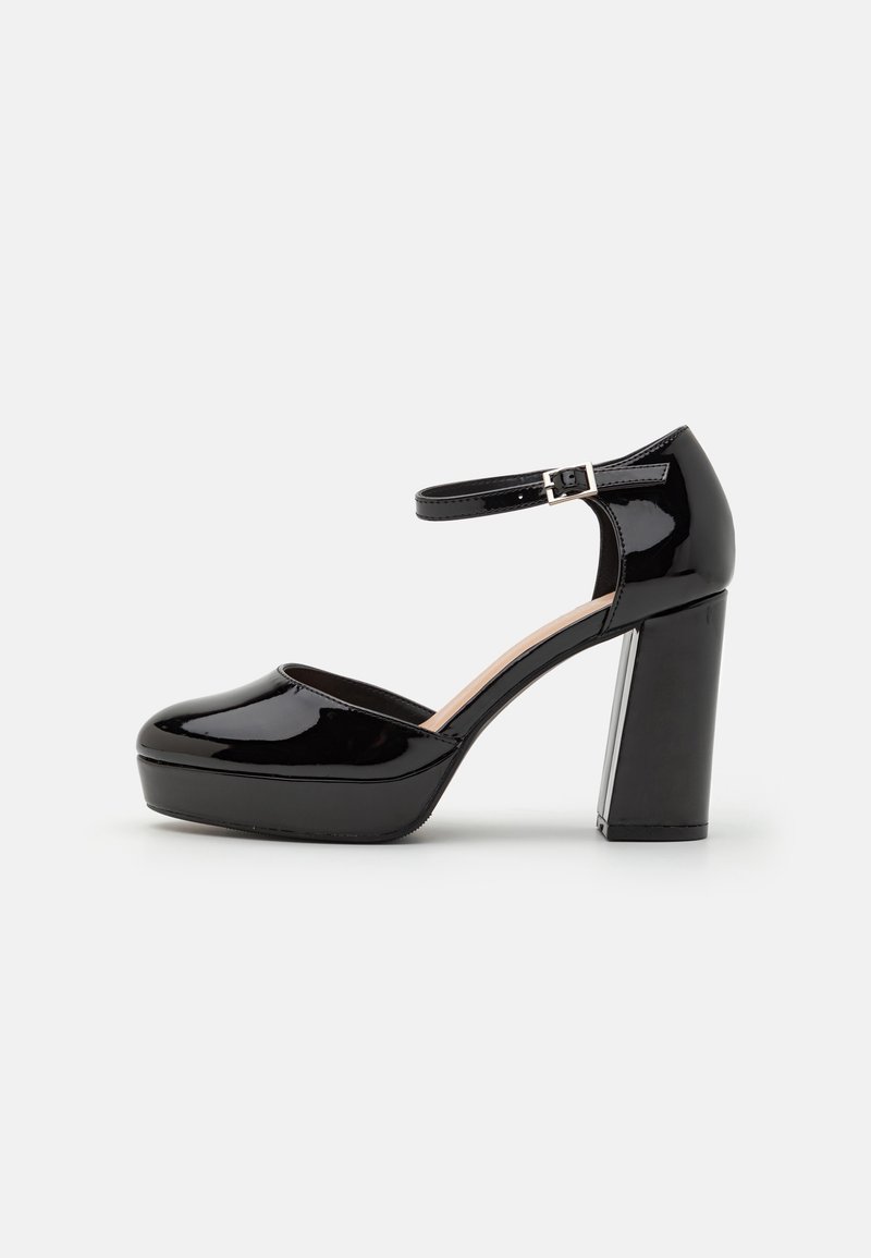 Chaussure à talon haut à plateforme en cuir verni noir avec bride de cheville et boucle argentée, bout arrondi et talon bloc épais.