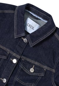Mörkblå denimjacka med klassisk krage, silverfärgade knappar och två bröstfickor. Stygn i en ljusare tråd.
