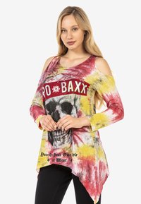 Langärmliges Tunika mit kalten Schultern in rot, gelb und schwarz im Batikdesign. Verfügt über eine Schädelgrafik und einen Text. Der Stoff hat eine weiche, lässige Passform.