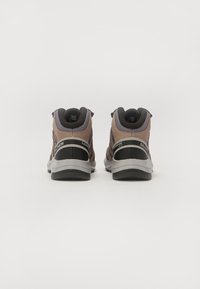 Bottes de randonnée mi-hautes marron et noires avec un matériau texturé, un col rembourré et des semelles en caoutchouc ; elles présentent des coutures renforcées et des accents de logo.