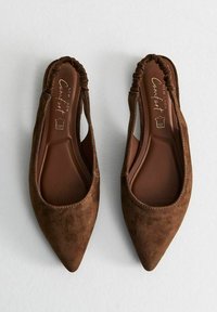 Bruine suède platte schoenen met een spitse neus, een elastische opening en een gladde bruine binnenzool. Het ontwerp heeft een slouchy, relaxed pasvorm.